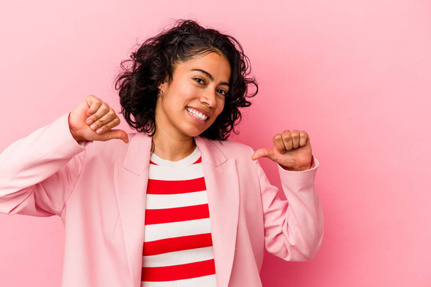Молодая модная латинская женщина на розовом фоне чувствует себя гордой и уверенной в себе, пример для подражания. - Фото, изображение