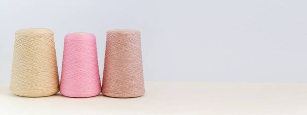 Bobbins of yarn in pastel colors. Copy space background - Zdjęcie, obraz