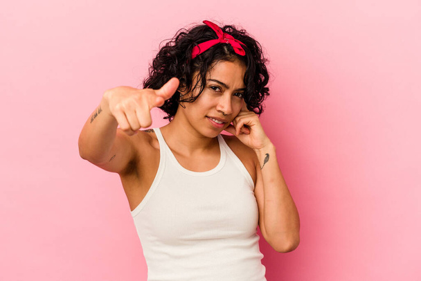 Young curly latin woman isolated on pink background pointing temple with finger, thinking, focused on a task. - Foto, Imagen