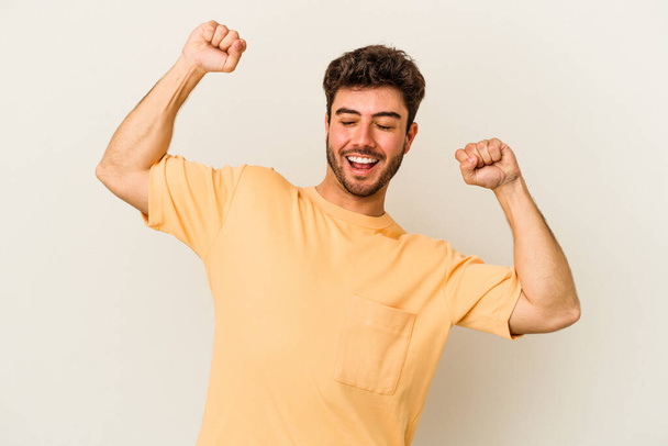 Young caucasian man isolated on white background celebrating a special day, jumps and raise arms with energy. - Fotografie, Obrázek