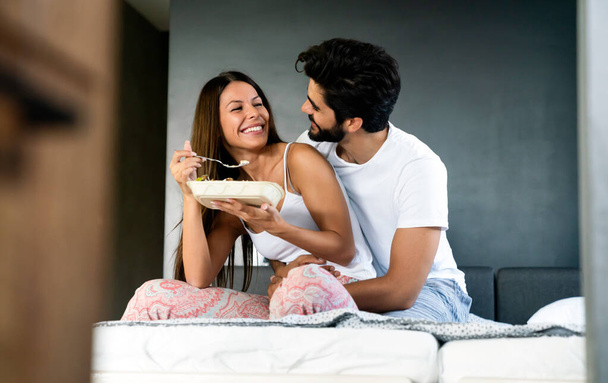 Good morning. Healthy breakfast in bed. Young beautiful couple in love spending time together - Photo, image