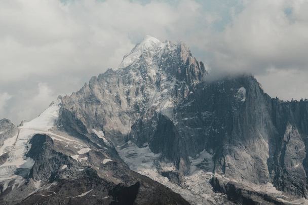 A scenery of a snowy mountains on a cloudy day - Фото, зображення