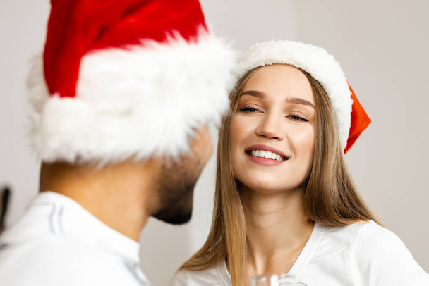 Cheerful attractive happy couple in Santa hats - Фото, зображення