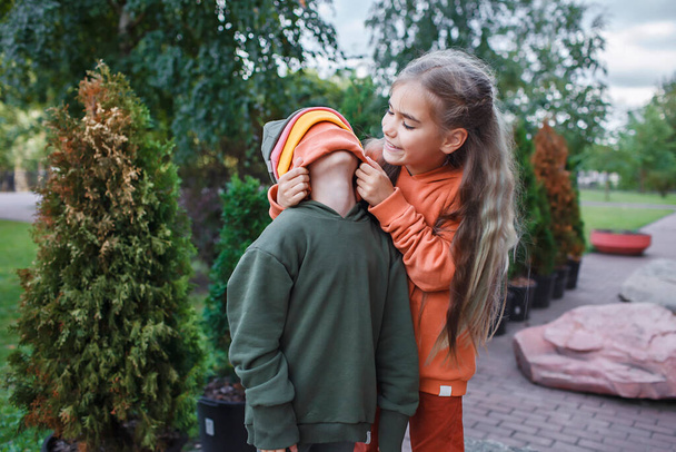 Kids in trendy hats and hoodies having fun in park, fall vibes, autumn beauty style, child fashion - Foto, immagini