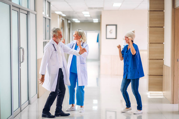 Szakmai orvos csapat sztetoszkóppal egyenruhában megvitatása és tánc boldog beteg nő rák fedél fej fejkendővel a kemoterápia rák a kórházban.egészségügyi ellátás - Fotó, kép