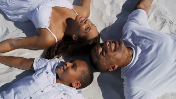 Famiglia sdraiata sulla sabbia insieme
 - Filmati, video