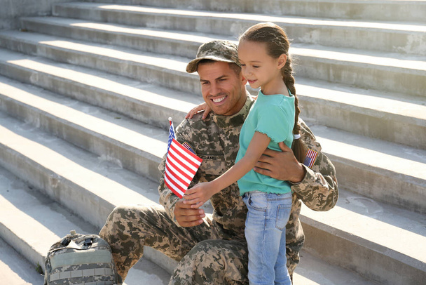 Soldier and his little daughter with flag of USA outdoors, space for text - Foto, Imagen