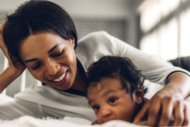 Muotokuva nauttia onnellinen rakkaus perheen afrikkalainen amerikkalainen äiti leikkii suloinen pieni afrikkalainen amerikkalainen baby.Mom koskettaa söpö poika hetkiä hyvää aikaa valkoinen makuuhuone.Rakkaus musta perhe - Valokuva, kuva