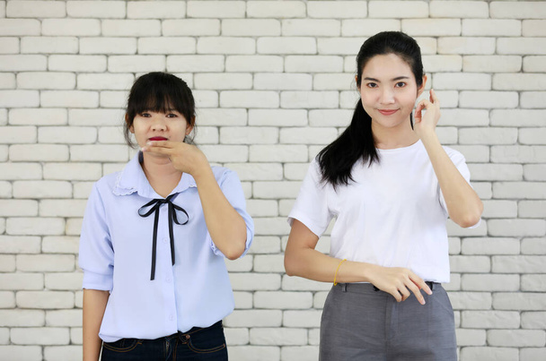 Dvě mladé a krásné Asain ženy učení a zobrazování dovednosti hluchých lidí komunikace, ruku a znakovou řeč. - Fotografie, Obrázek