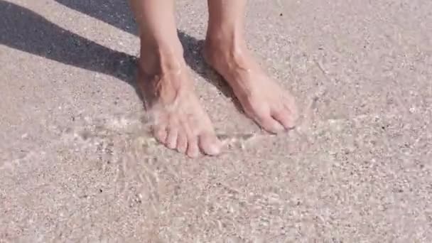 Női láb a vízben a tengerparton. 4k videofelvétel minősége. Tengeri téma - Felvétel, videó