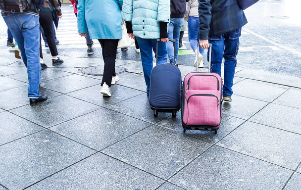Люди в толпе с чемоданами едут на вокзал осенью на каникулы - Фото, изображение