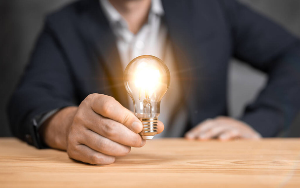 Man holding light bulbs, ideas of new ideas with innovative technology and creativity. concept creativity with bulbs that shine glitter. Innovative technology in science and communication concept - Foto, afbeelding