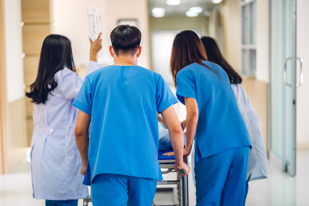 Group of professional medical doctor team and assistant with stethoscope in uniform taking seriously injured patient to operation emergency theatre room in hospital.health medical care concept - Foto, imagen