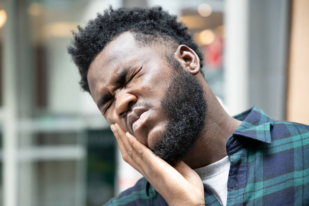 African man with toothache; portrait of black man suffering from toothache pain, tooth decay, tooth sensitivity; girl oral health care, dental care concept; african 20s adult man model - Foto, afbeelding
