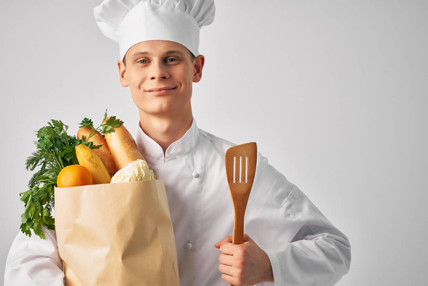 a man in a chefs uniform a package of products restaurant work service - 写真・画像
