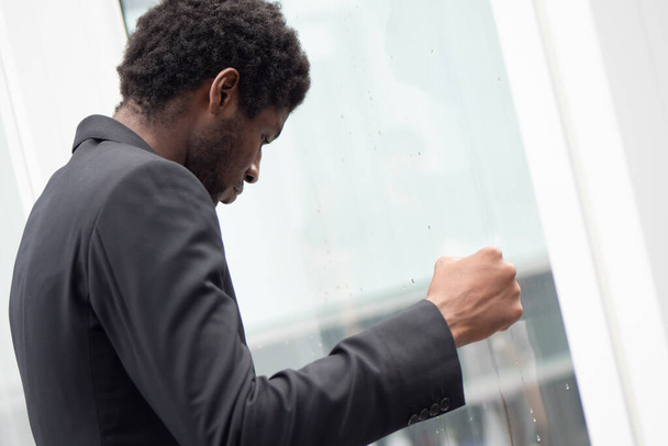 Angry upset African black businessman, portrait of failed unhappy black business man punching glass window, concept of work problem, office stress syndrome, economic recession, layoff, unemployment - Photo, Image