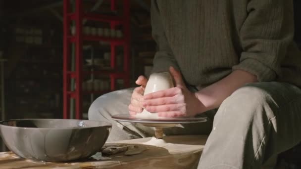 Potter está dando forma a la arcilla húmeda en la rueda de alfareros - Imágenes, Vídeo