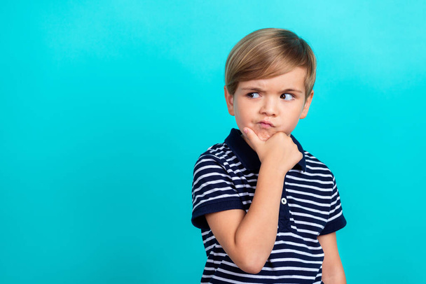 Photo of think small boy hand chin look empty space wear striped t-shirt isolated on teal color background - 写真・画像