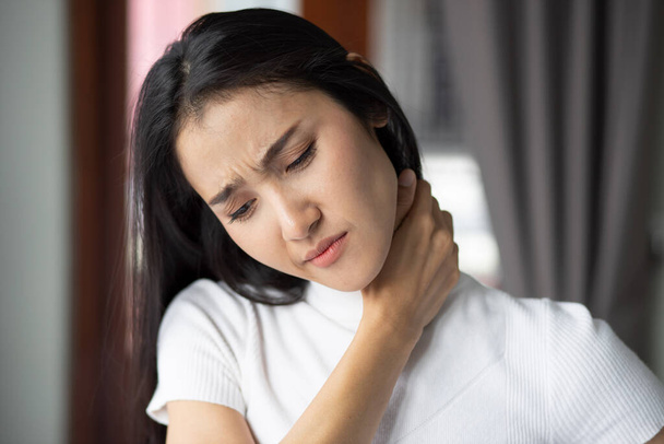 woman with shoulder or neck pain, portrait of asian woman suffering from shoulder or neck pain, stiffness, injury, chronic bone or muscle injury concept - Fotografie, Obrázek