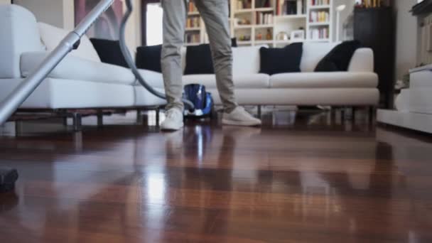 Hombre que limpia el suelo de la casa con aspiradora - Metraje, vídeo