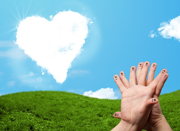 Onnellinen hymiö sormet katsomalla sydämen muotoinen pilvi - Valokuva, kuva