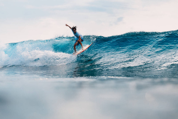 April 11, 2019. Bali, Indonesia. Indonesian surfer Alik Rudiarta training on surfboard at ocean wave.  - Фото, изображение