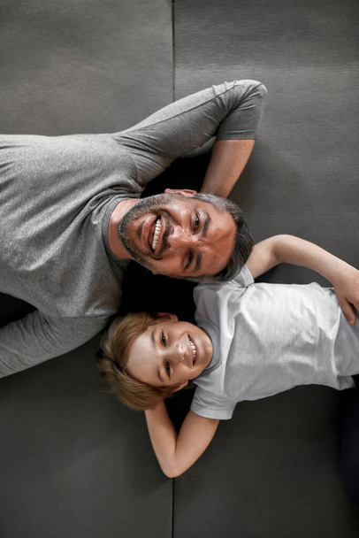 Vertical portrait of smiling Caucasian father and son relaxing - Photo, image