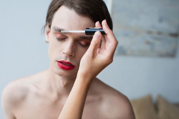 maquiador aplicando gel de sobrancelha no homem transexual  - Foto, Imagem