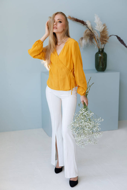 блоггер в стильном образе с сухими цветами. Осенняя одежда - Фото, изображение