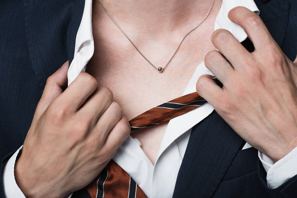 recortado vista de hombre transgénero ajustando camisa y mostrando collar de plata - Foto, Imagen