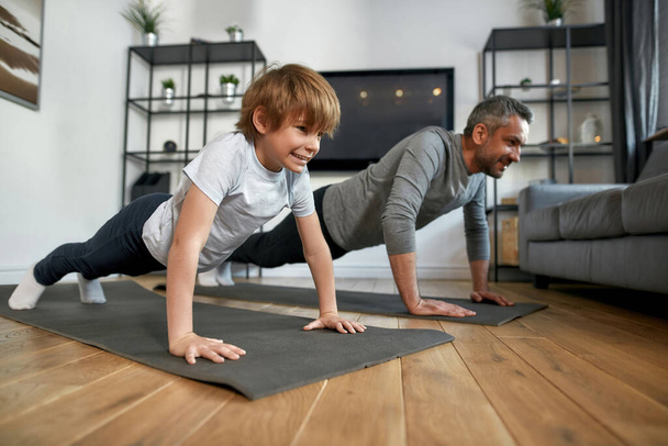 Happy sporty father and son train together at home - Foto, Imagem