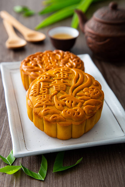 Moon cakes with Chinese tea. The Chinese character on the mooncake represent "Pandan lotus paste with single york" in English - Photo, Image