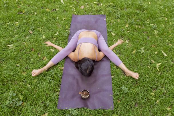 Mulher fazendo poses de ioga na grama verde no parque - Foto, Imagem