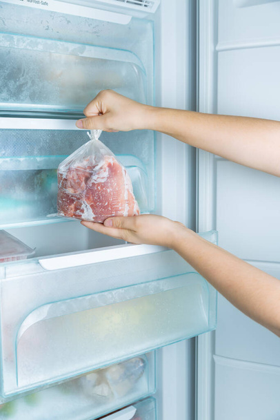 Tomando a carne congelada do congelador sem geada moderno - Foto, Imagem