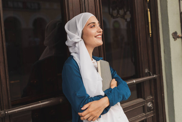 A fiatal muszlim lány hidzsábot visel naplófüzetben. Iszlám diák és tudás koncepció. - Fotó, kép