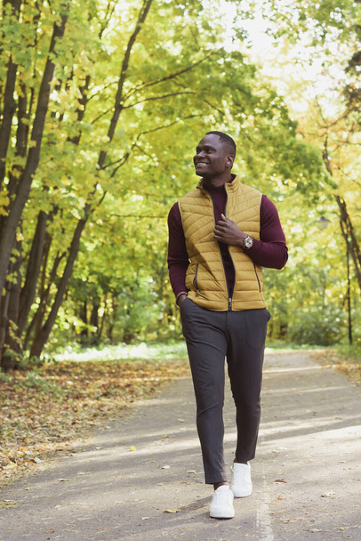 Африканський студент - американець, який ходить парком восени. - Фото, зображення