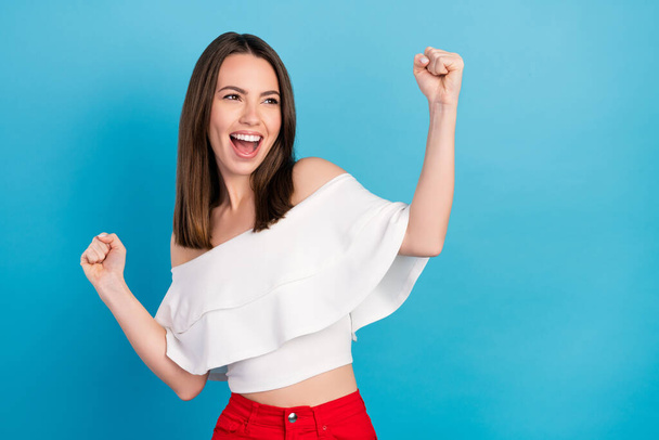 Photo of cheerful young crazy happy woman look empty space winner celebrate isolated on blue color background - Valokuva, kuva
