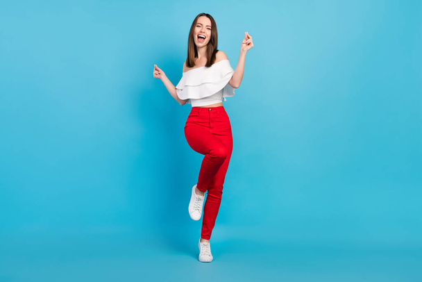 Full length photo of happy cheerful young woman dance good mood isolated on pastel blue color background - Zdjęcie, obraz