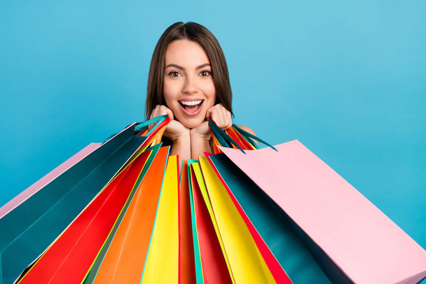 Photo of happy charming young positive woman amazed sale hold bags customer isolated on blue color background - Fotoğraf, Görsel
