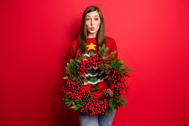 Photo of nice millennial lady hold door decoration wear holiday sweater isolated on red color background - Foto, Imagen