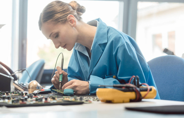 Worker in electronics manufacturing soldering a component - Photo, Image