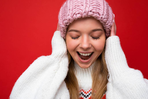Close-up foto van mooie positieve vrolijke jonge blonde vrouw geïsoleerd over kleurrijke achtergrond muur dragen dagelijks trendy kleding tonen gezicht emoties - Foto, afbeelding