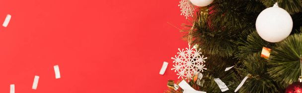 close up view of christmas tree with decorative snowflakes and balls isolated on red, banner - Fotografie, Obrázek