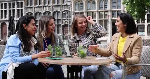 Aantrekkelijke jonge vrouwen van gemengd ras die buiten feesten in de stad, cocktails drinken en glimlachen en juichen. - Video