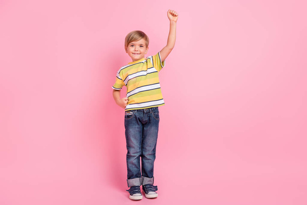 Full size photo of cheerful happy small boy raise hand super hero smile enjoy isolated on pink color background - Zdjęcie, obraz