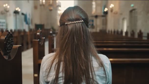 Vrouw zit in een kerk en bidt. - Video