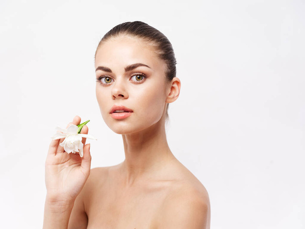 woman with a flower in her hands naked shoulders cosmetics attractive look - Zdjęcie, obraz