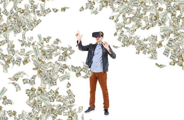 Dollar-Banknoten fliegen um jungen Mann mit Virtual-Reality-Brille, Virtual-Reality-Konzept. - Foto, Bild