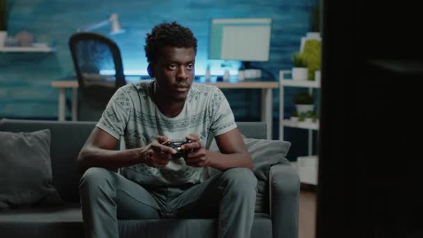 Black man using controller and console to play video games - Footage, Video
