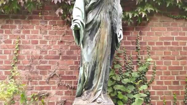 Bronzen standbeeld van een spirituele engel figuur op een kerkhof als culturele heilige geest en ziel geschiedenis op het kerkhof als bewaker van de doden en iconische monument symbool voor religieuze graven met vleugels - Video